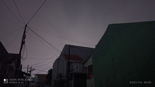 Low angle view of buildings against sky at night