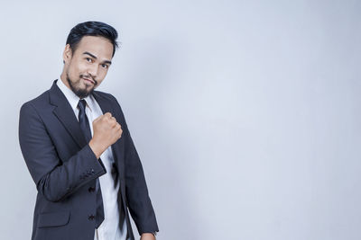 Portrait of man standing against white background