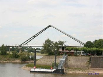 Bridge against cloudy sky