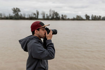 Man looking away while standing on shore