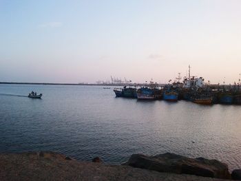 Boats in harbor at sunset