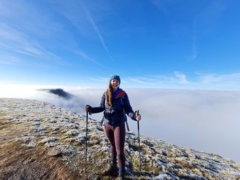 Full length of woman standing on mountain against sky