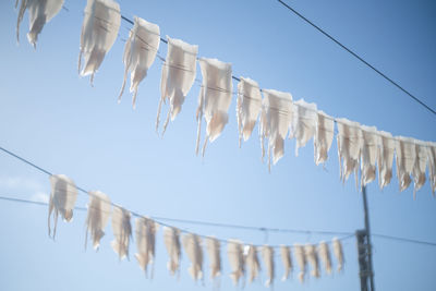 Low angle view of clothes drying on clothesline against clear sky