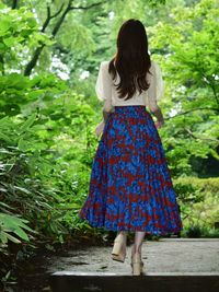 Rear view of woman standing against plants