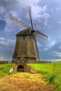 Traditional windmill against cloudy sky