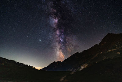 Scenic view of mountains against sky at night