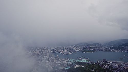 High angle view of cityscape by sea against sky