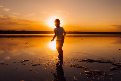 Silhouette of male child in sunlight rays. fresh air, environment concept.