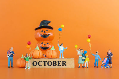 Various toys on shelf against orange background