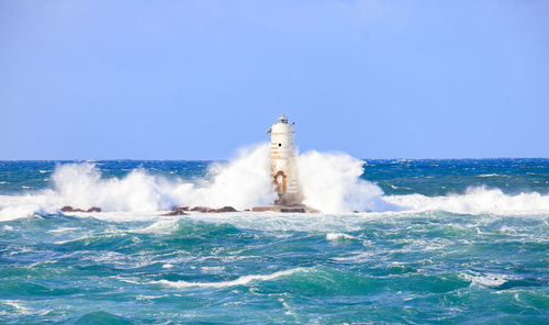 The lighthouse of the mangiabarche shrouded by the waves of a mistral wind storm
