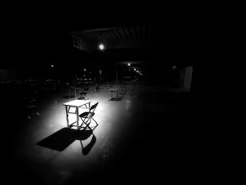 Empty chairs and tables in illuminated dark room
