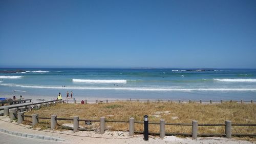 Scenic view of beach against clear blue sky