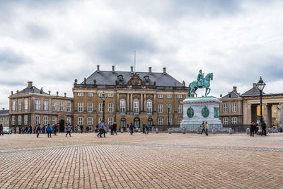 Walkway and historical building against cloudy sky