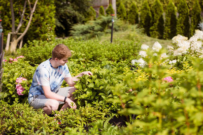 Full length of man holding flowering plants