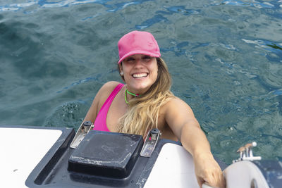 A woman on top of a boat against the sea in the background. 