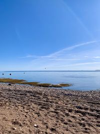 Scenic view of beach against blue sky