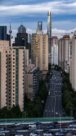 Modern buildings in city against cloudy sky