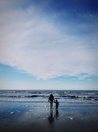 People on beach against sky