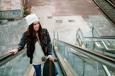 Young woman standing on escalator