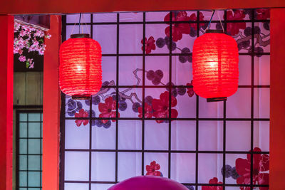 Red lanterns hanging on glass wall