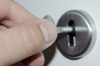 Cropped image of hand inserting key in hole