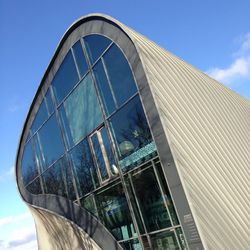 Low angle view of glass building against blue sky