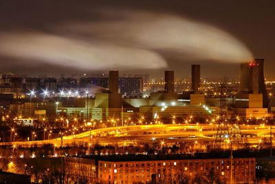 Strong wind bending smoke from factory smokestacks in the night