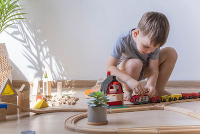 Side view of boy playing with toy on table at home