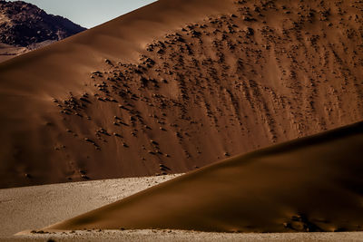 Scenic view of sand dunes against sky