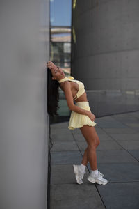 Low section of woman standing against wall
