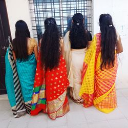 Rear view of women standing on tiled floor