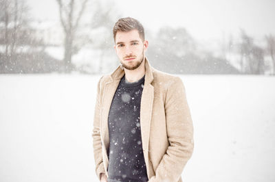 Portrait of young man standing in snow
