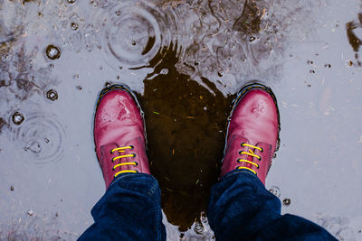 Low section of man standing in puddle