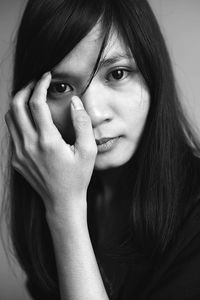 Portrait of young woman against wall