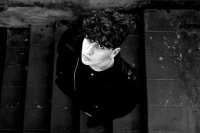 Portrait of young man standing against wall