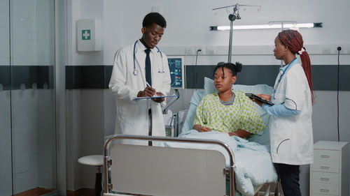 Doctors examining patient in ward at hospital