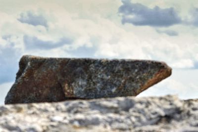 Close-up of rusty rock against sky