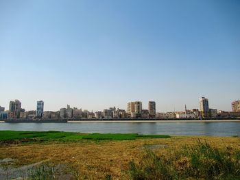 Buildings in city against clear sky