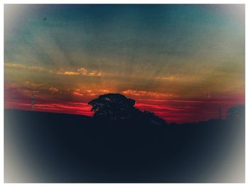 Silhouette landscape against romantic sky at sunset