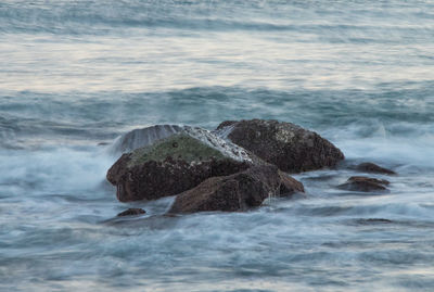 Rocks in sea against sky