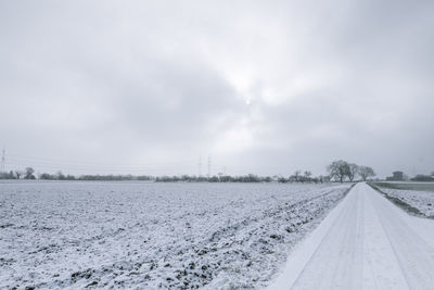 Surface level of empty agricultural field against cloudy sky