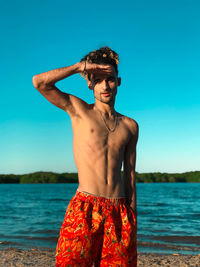 Portrait of shirtless man standing at beach