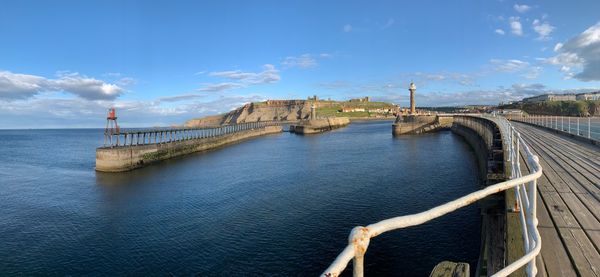 Bridge over sea against blue sky