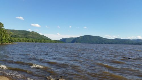 Scenic view of sea and mountains against sky