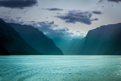 Scenic view of fjord and mountains against sky