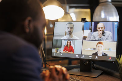 Rear view of woman using laptop at home