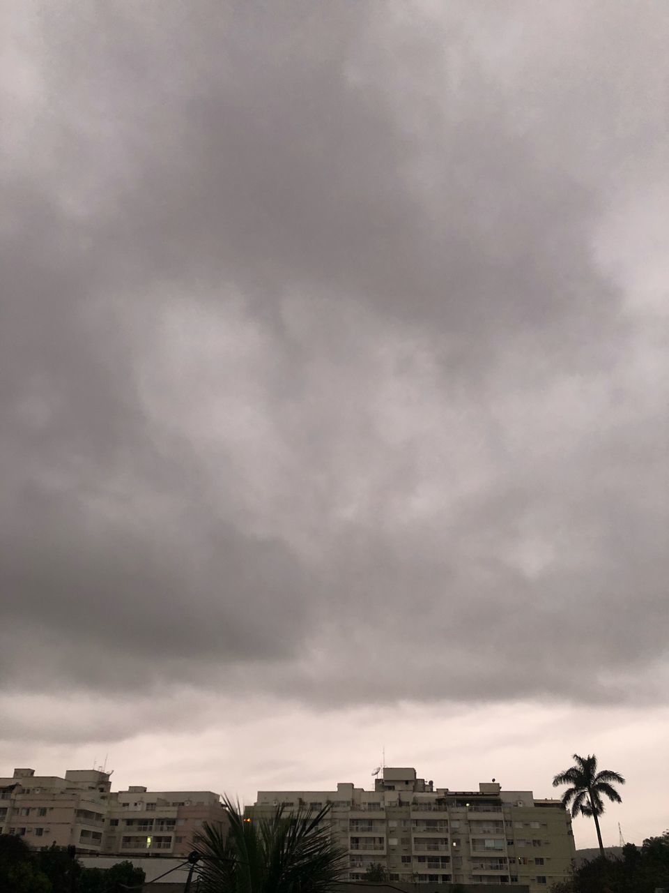 LOW ANGLE VIEW OF BUILDINGS AGAINST STORM CLOUDS