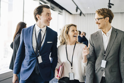 Happy female walking with coworkers in office