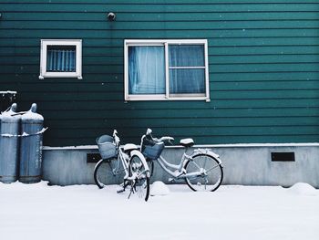 Bicycles parked by house in snow