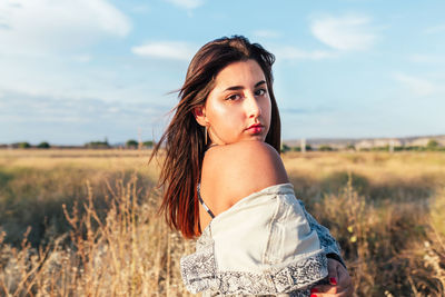 Beautiful teenager posing sideways in the countryside